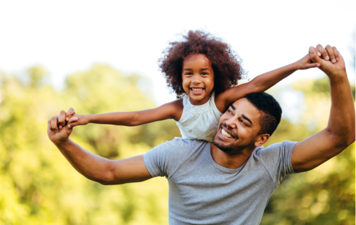 father and daughter smiling outside