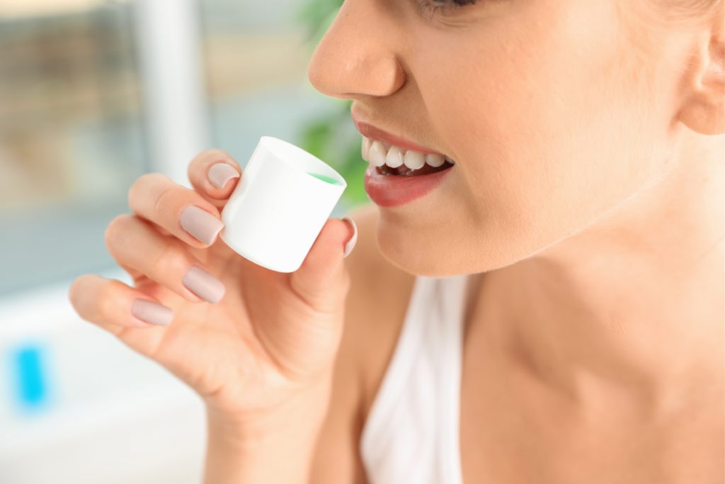 dental patient using a fluoride mouth rinse