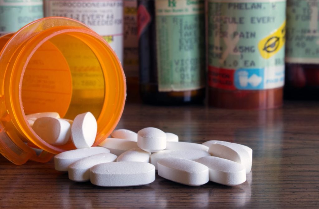 Sedation dentistry pills spilling from a bottle on a wooden surface