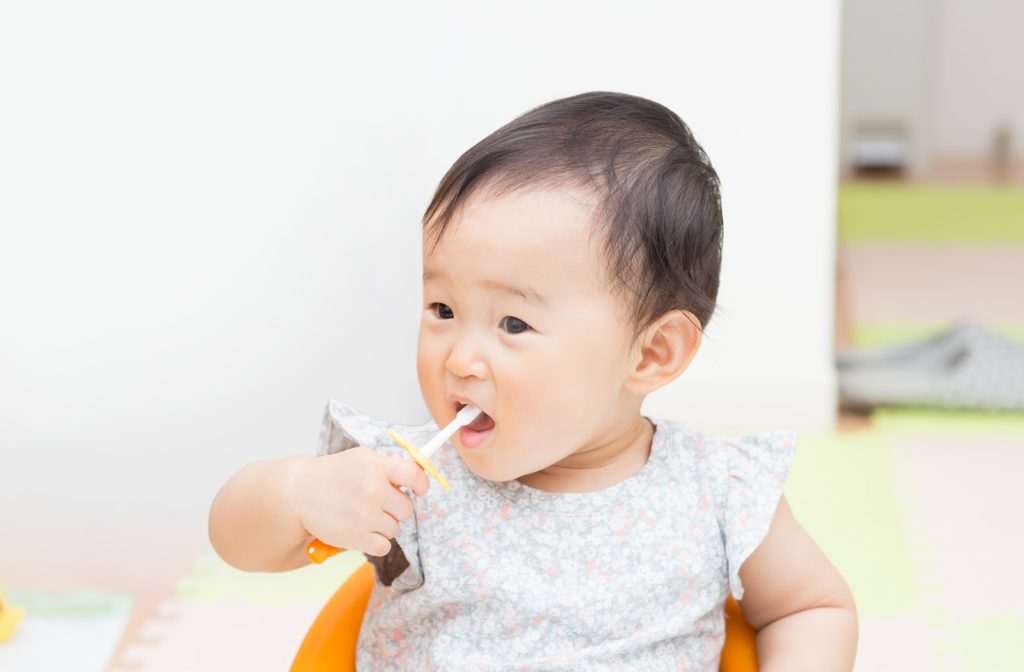 Cute baby using toothbrush to clean teeth safely