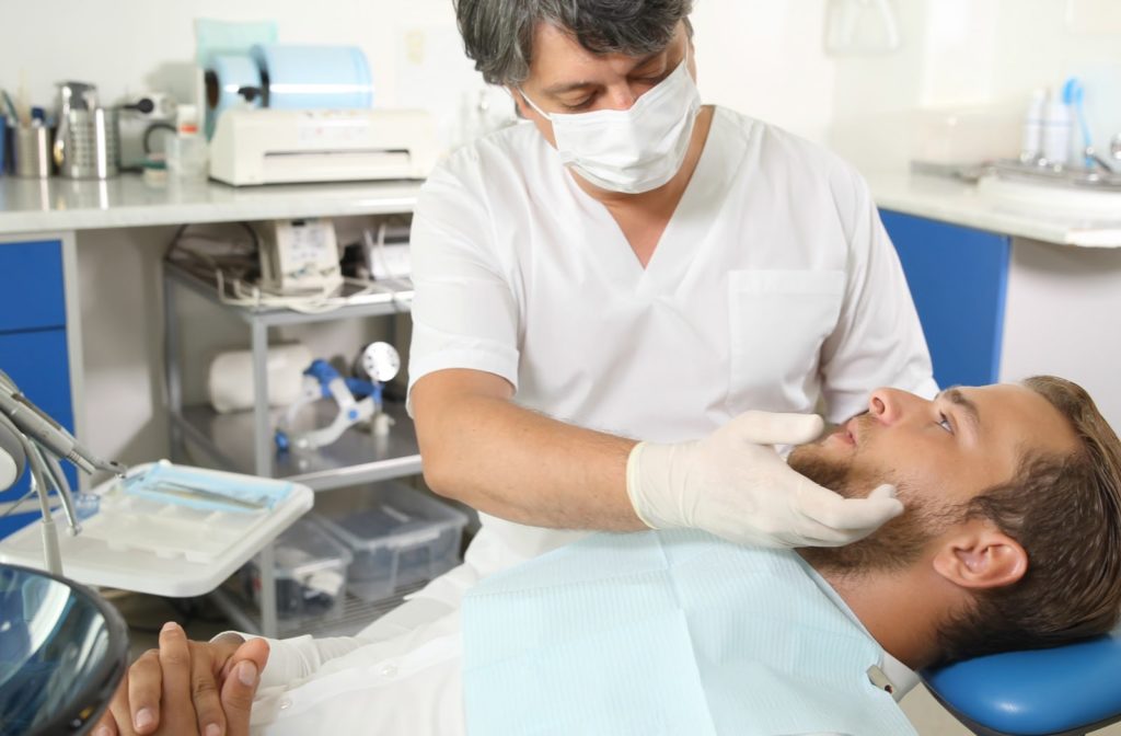 Patient being examined by his dentist after explaining the symptoms he's been feeling