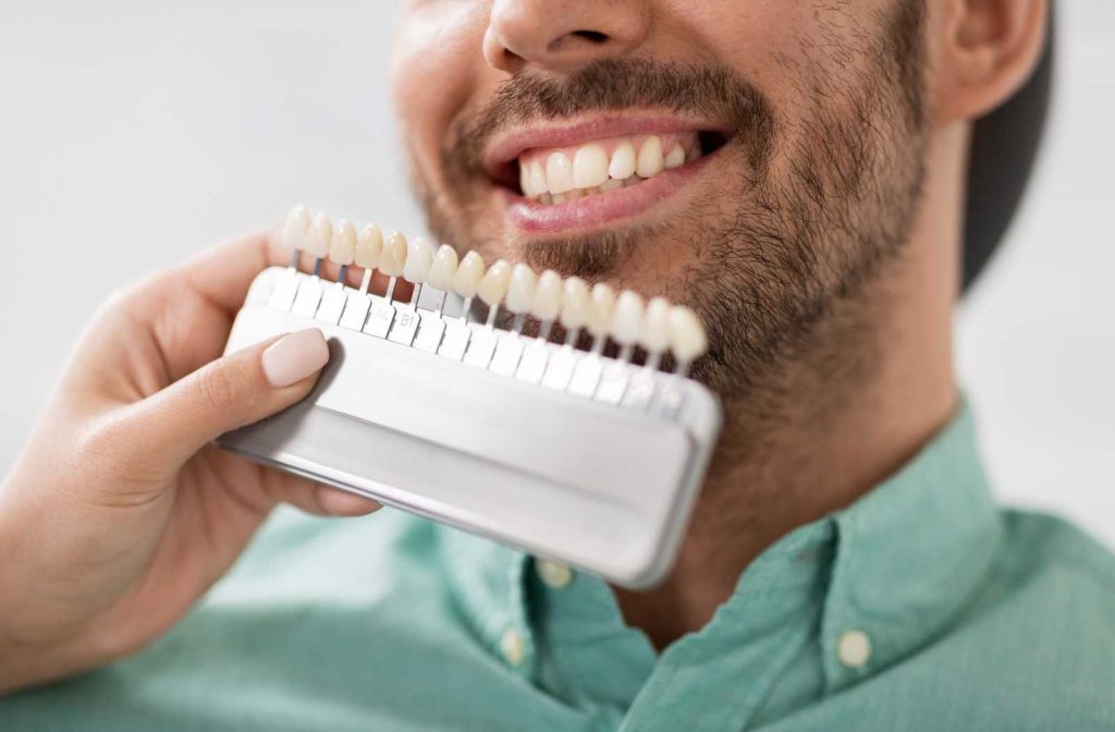 selecting veneers by dental shade with smiling patient in background