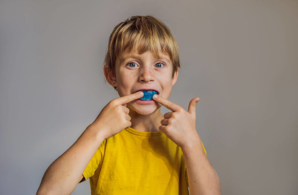 A boy shows a blue-coloured mouth guard to protect his teeth from grinding.