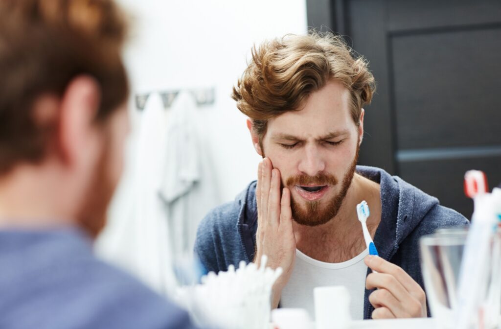 An adult realizes they need to be more gentle while brushing because they're experiencing tooth sensitivity while brushing their teeth.