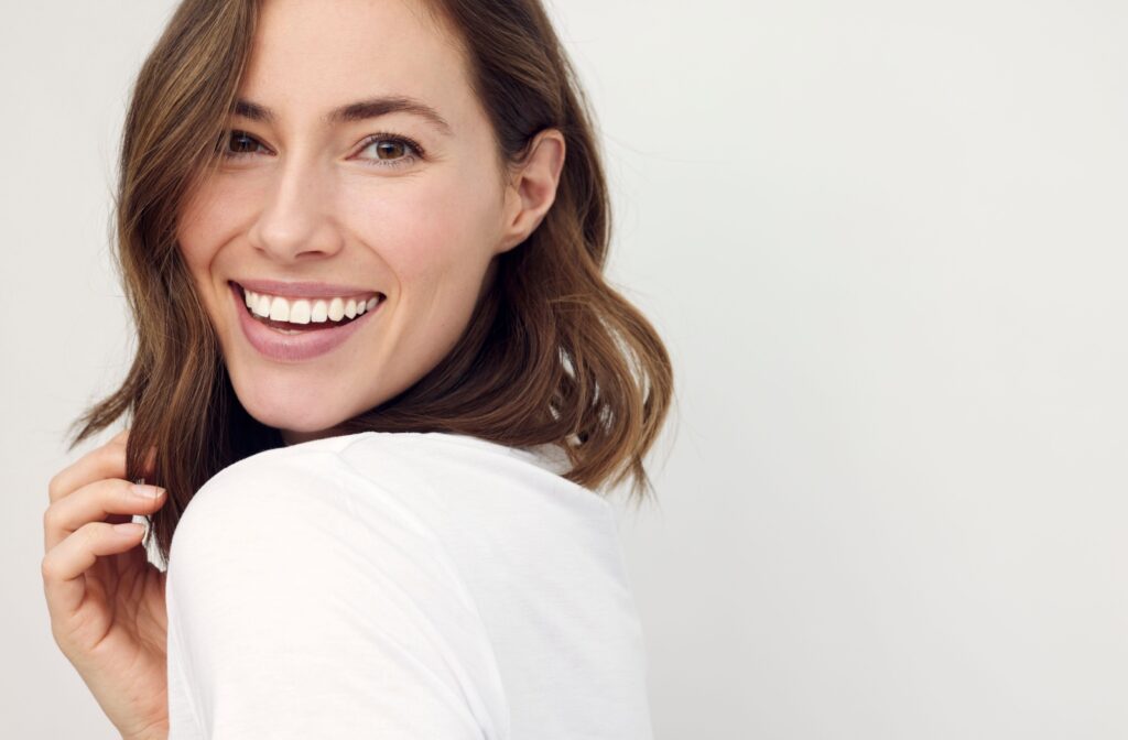 A person smiling after treatment for their crooked teeth.