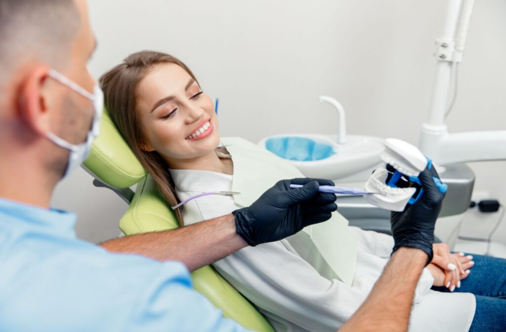 A dentist explains dental treatments to their patient during a cleaning and exam.