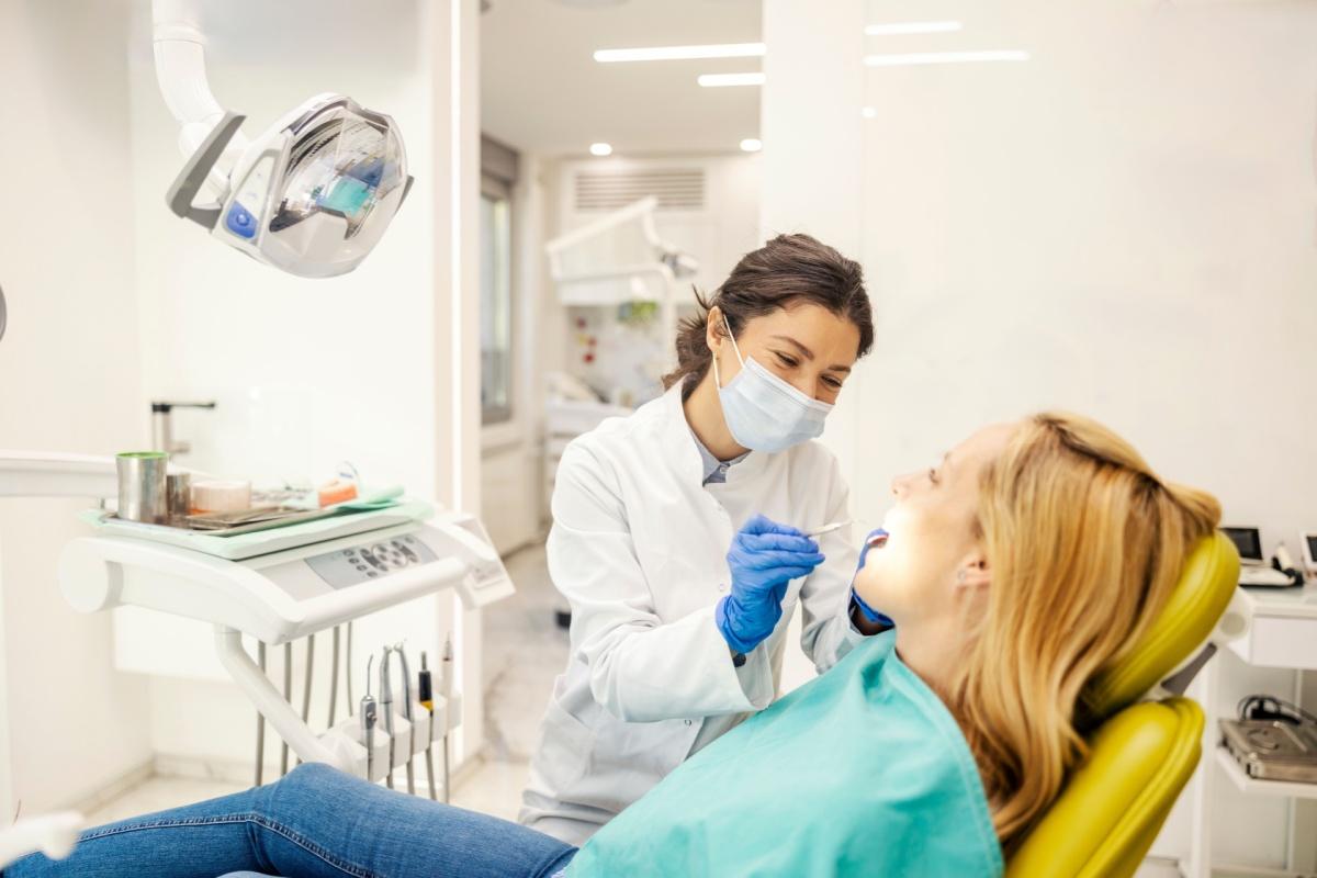 A dentist checking on a patients teeth during a routine dental exam.